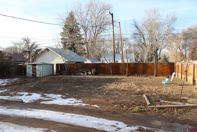 snowy yard featuring a storage shed