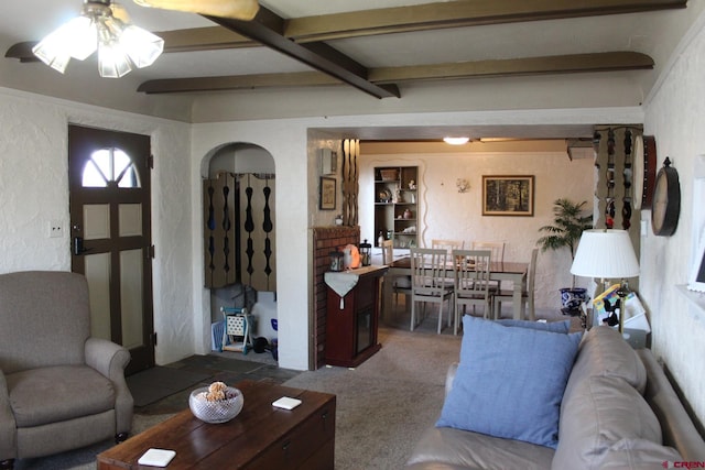 carpeted living room with ceiling fan and beam ceiling