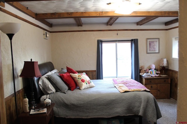 bedroom with beam ceiling and carpet floors