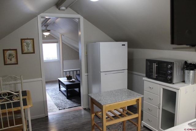 kitchen featuring dark hardwood / wood-style flooring, vaulted ceiling, ceiling fan, white fridge, and white cabinetry