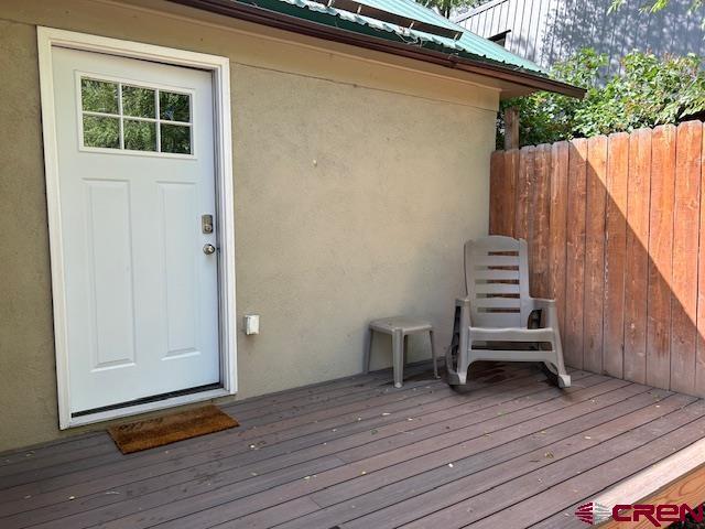 view of exterior entry featuring a wooden deck