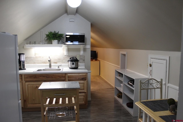 kitchen featuring backsplash, sink, white refrigerator, dark hardwood / wood-style floors, and lofted ceiling