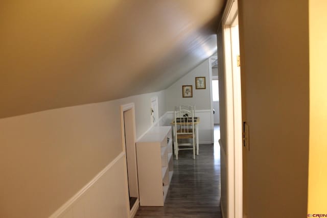 corridor featuring dark hardwood / wood-style flooring and vaulted ceiling