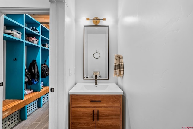 mudroom with sink and light hardwood / wood-style flooring