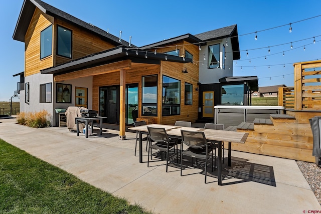 back of house featuring a jacuzzi and a patio