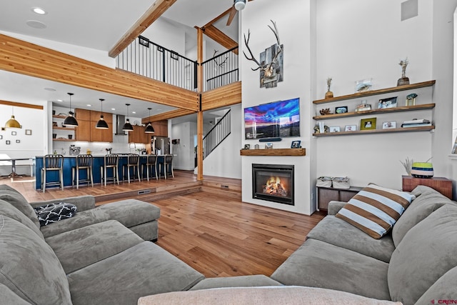 living room featuring a towering ceiling and light hardwood / wood-style floors