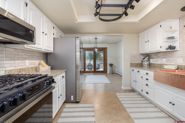 kitchen with a raised ceiling, white cabinetry, and stainless steel appliances