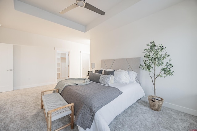 bedroom featuring carpet, ceiling fan, and a raised ceiling