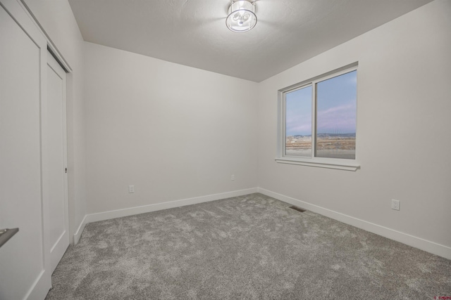 unfurnished bedroom with light carpet and a closet