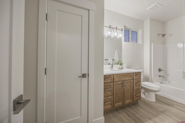 full bathroom featuring hardwood / wood-style floors, vanity, toilet, and shower / tub combination