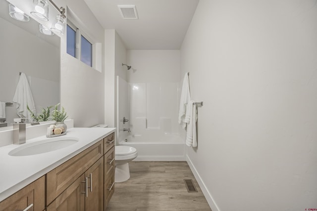 full bathroom featuring washtub / shower combination, hardwood / wood-style floors, vanity, and toilet