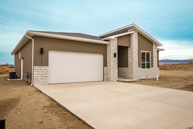 view of front facade with a mountain view, central AC, and a garage