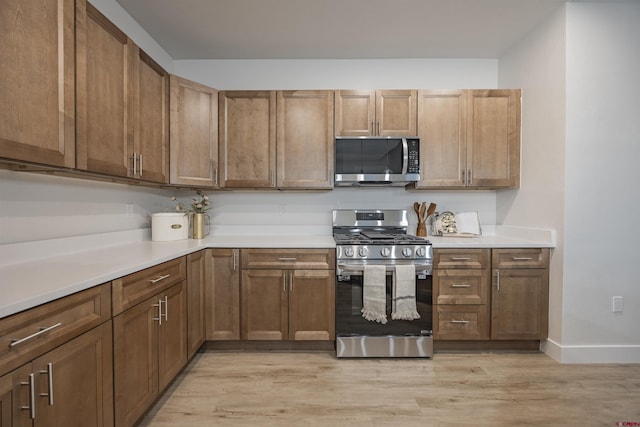 kitchen with stainless steel appliances and light hardwood / wood-style flooring