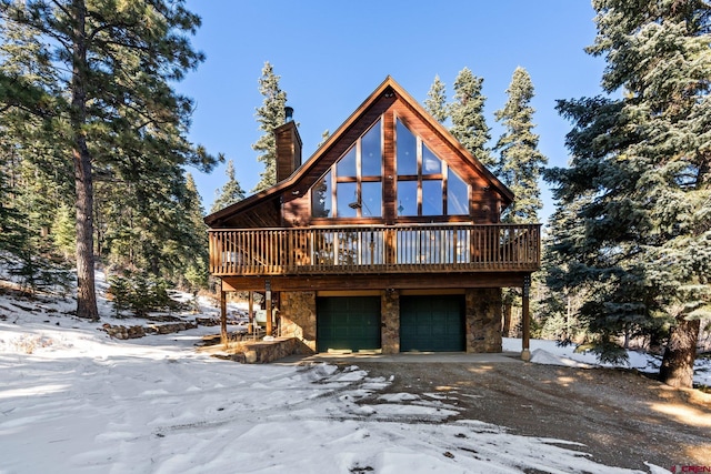 log cabin featuring a wooden deck and a garage