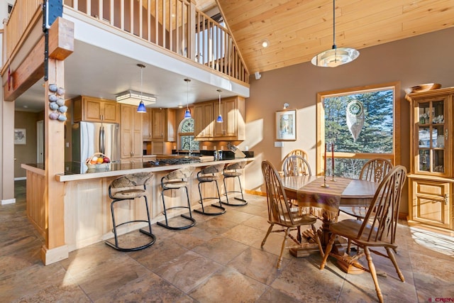 dining room with a towering ceiling, sink, and wooden ceiling