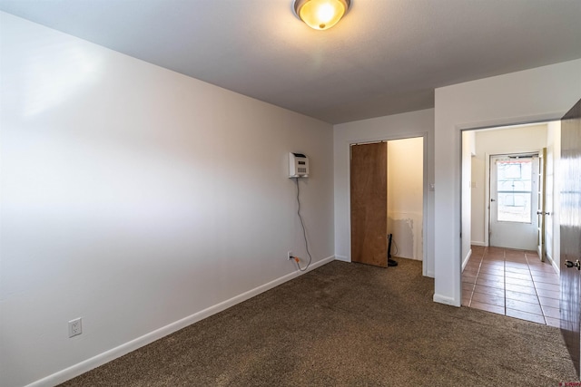 unfurnished bedroom with a wall mounted AC, carpet floors, and a closet