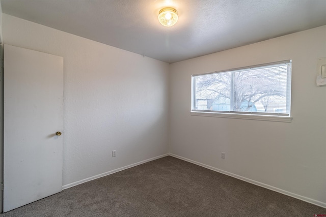 empty room featuring dark carpet