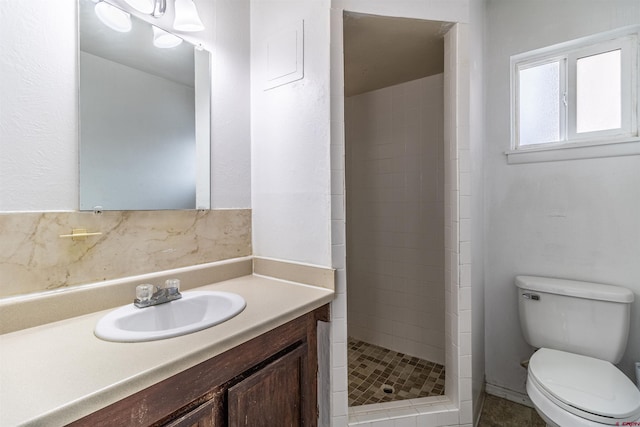 bathroom featuring tiled shower, vanity, and toilet