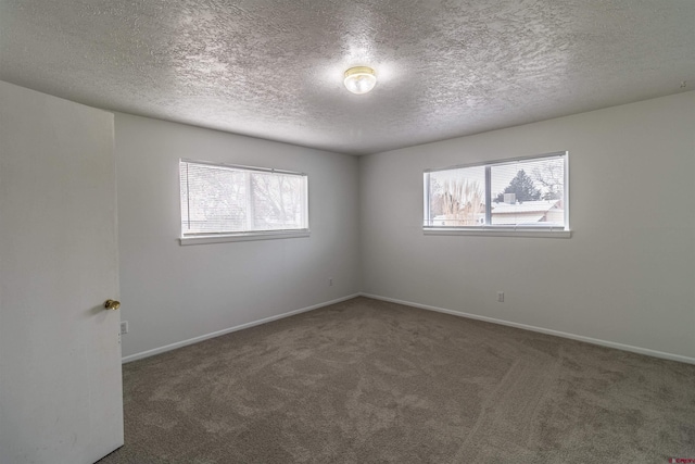 carpeted spare room featuring a textured ceiling