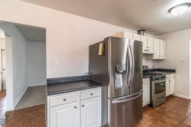 kitchen featuring dark colored carpet, appliances with stainless steel finishes, and white cabinetry