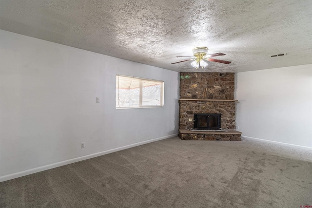 unfurnished living room with ceiling fan, a fireplace, carpet, and a textured ceiling