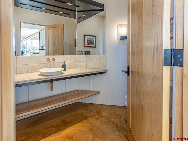 bathroom with vanity, tasteful backsplash, and toilet
