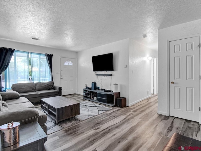 living room with wood-type flooring and a textured ceiling