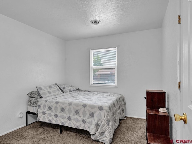 bedroom with carpet flooring and a textured ceiling