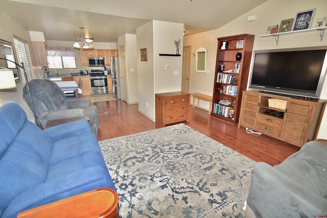 living room featuring a textured ceiling, light hardwood / wood-style flooring, and lofted ceiling