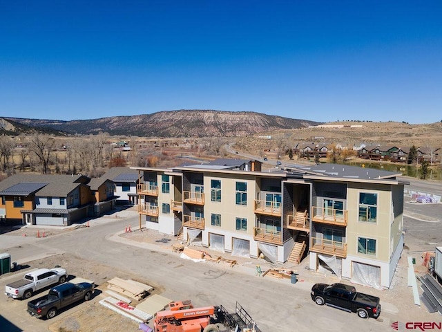 view of building exterior with a residential view and a mountain view