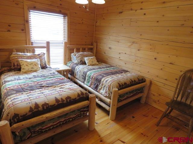 bedroom featuring wooden walls and light wood-type flooring