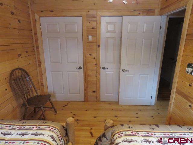 bedroom with wooden walls and a closet