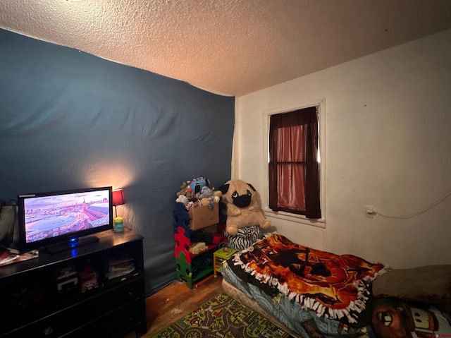 bedroom with hardwood / wood-style floors and a textured ceiling