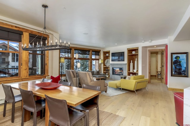 dining space with a notable chandelier and light wood-type flooring