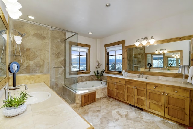 bathroom with vanity and a relaxing tiled tub