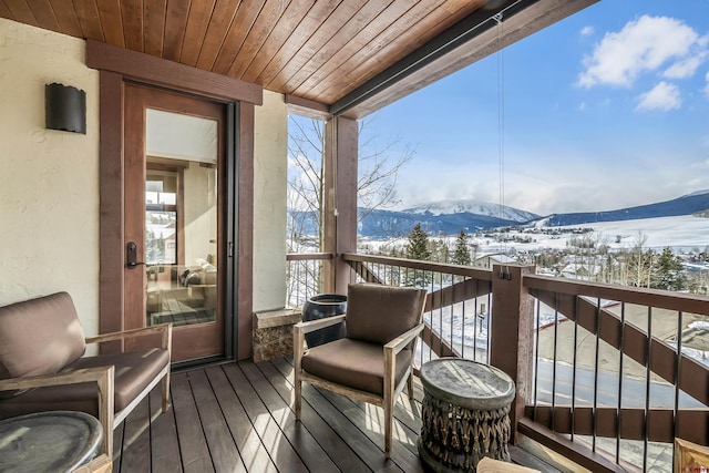 snow covered back of property featuring a mountain view