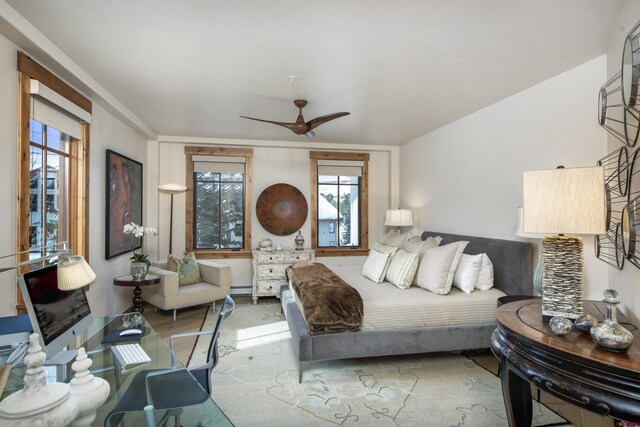 bedroom with ceiling fan and baseboard heating