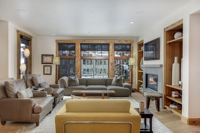 living room with light hardwood / wood-style flooring, built in shelves, and a wealth of natural light