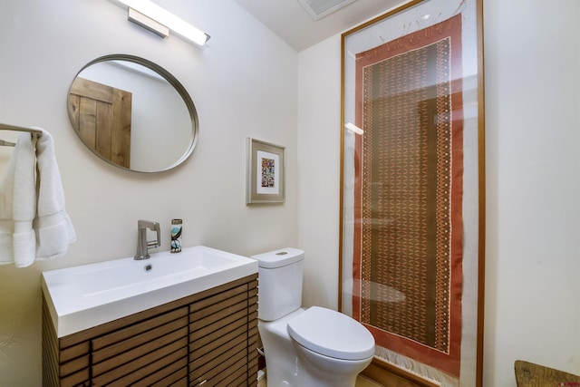 bathroom featuring walk in shower, vanity, and toilet