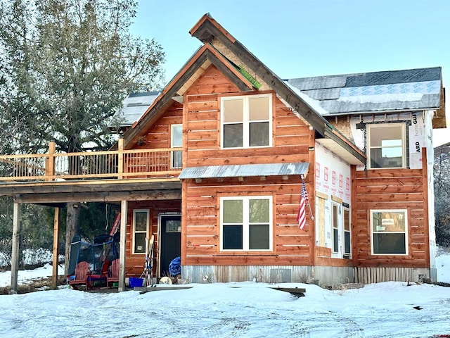 snow covered property with a trampoline and a deck