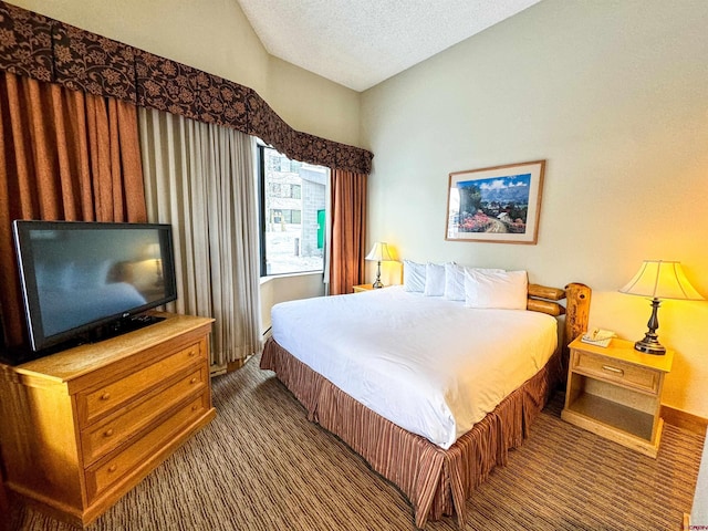 bedroom with a textured ceiling, carpet floors, and vaulted ceiling