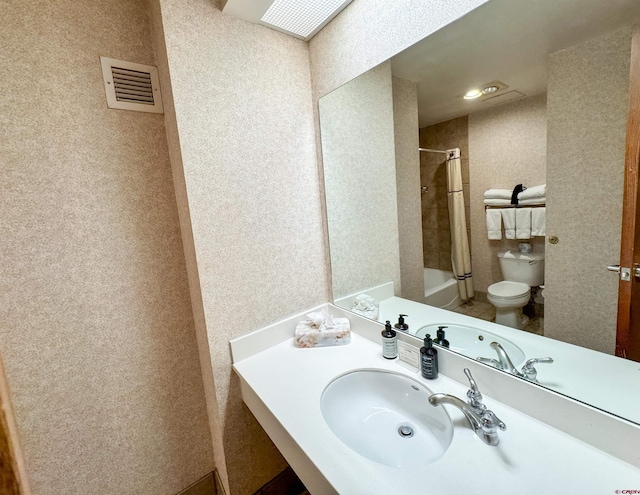 full bathroom featuring toilet, shower / bath combo with shower curtain, and sink