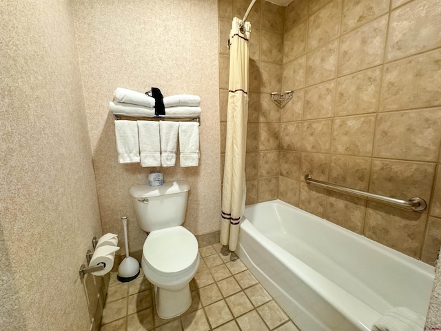 bathroom with tile patterned flooring, shower / bath combo, and toilet