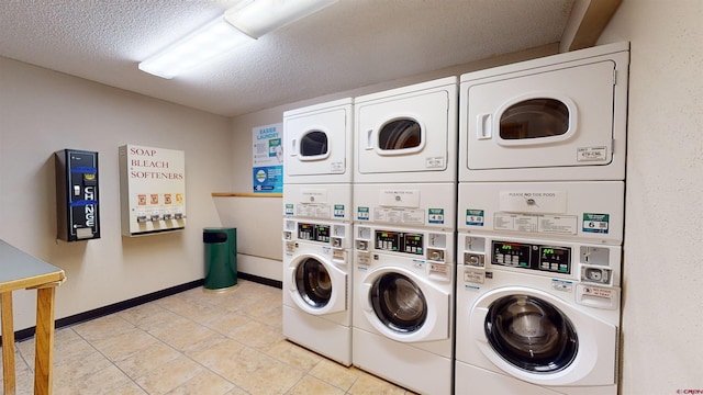 laundry room with light tile patterned flooring, a textured ceiling, stacked washer and clothes dryer, and washing machine and clothes dryer