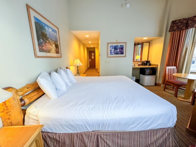 bedroom featuring carpet and a high ceiling