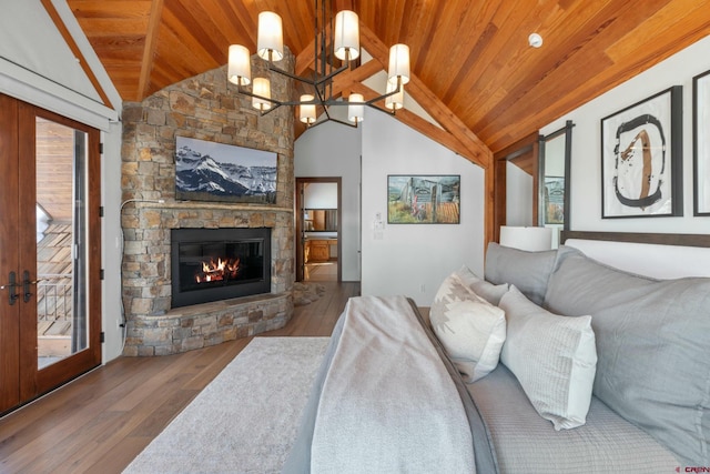 living room featuring french doors, vaulted ceiling, a fireplace, wood ceiling, and a chandelier