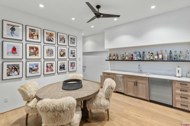 bar featuring dishwasher, refrigerator, sink, light hardwood / wood-style flooring, and ceiling fan