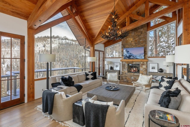 living room featuring beam ceiling, plenty of natural light, high vaulted ceiling, and a notable chandelier