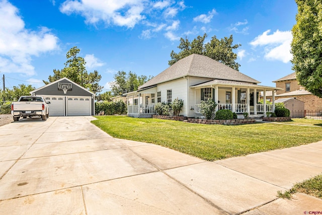 view of front facade with an outbuilding, covered porch, a front yard, and a garage