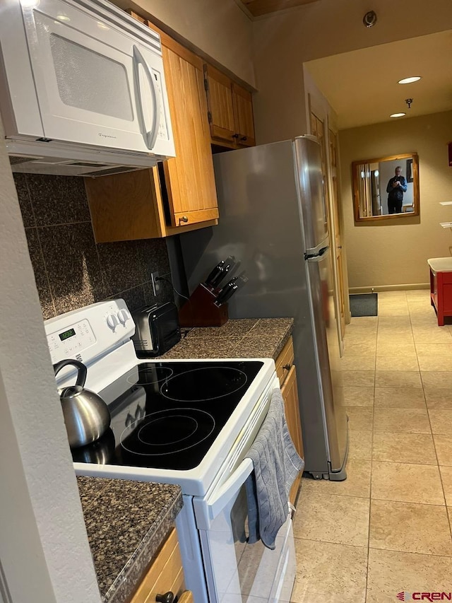 kitchen with decorative backsplash, light tile patterned flooring, and white appliances